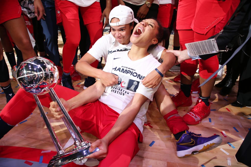 Aerial Powers and Kristi Toliver celebrate with the Mystics' trophy