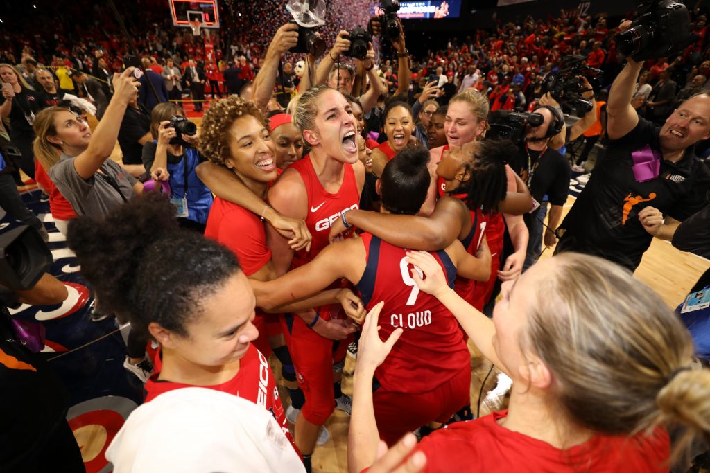 The Mystics celebrate on the court after the final buzzer sounds.