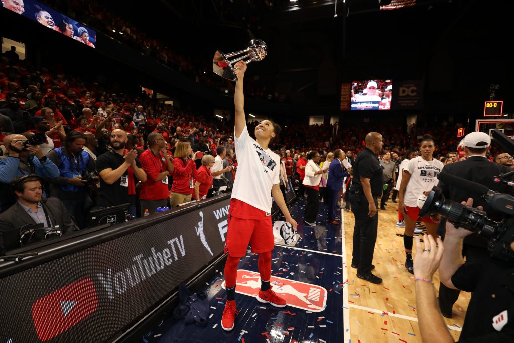 Aerial Powers raises the WNBA Finals trophy in celebration.