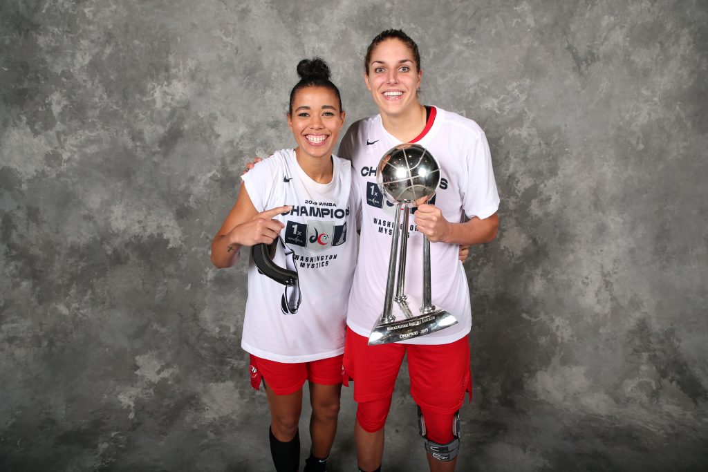 Natasha Cloud and Elena Delle Donne pose with the WNBA Finals trophy.