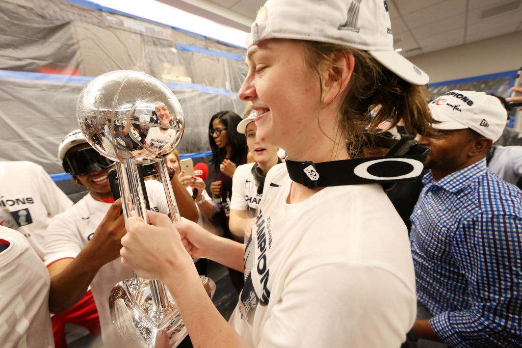 Emma Meesseman celebrates with the WNBA Finals trophy in the locker room.